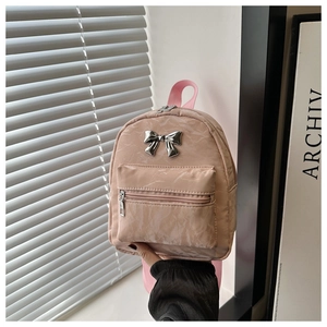 Detailed macro of pink textured mini backpack with a silver metal bow accent