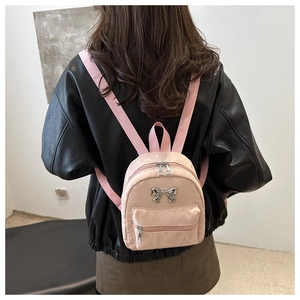 Détail du dos d'un mini sac à dos rose avec noeud métallique et fermeture éclair élégante