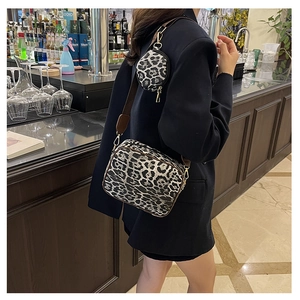 Detailed view of leopard print crossbody bag with a round coin purse and gold hardware