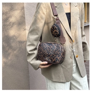Detail of leopard print crossbody bag with detachable round coin purse on a wide strap