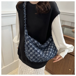 Dettaglio della borsa in denim a scacchi blu e bianchi con frange e tracolla