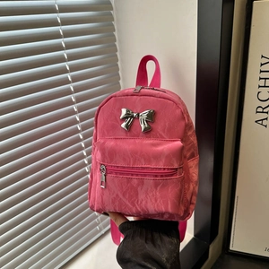 Pink pleated mini backpack featuring a metallic silver bow and stylish front zip pocket