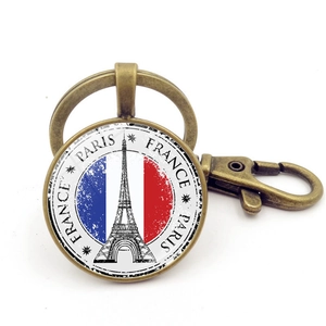 Dettaglio portachiavi in bronzo con Torre Eiffel e bandiera francese sotto vetro curvo