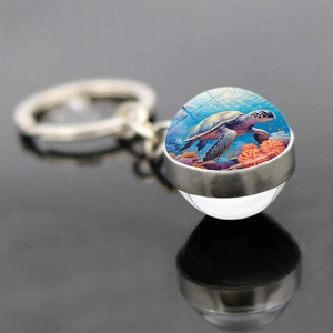 Vue macro d'un porte-clés globe en verre tortue marine avec base en alliage et reflet net