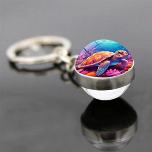 Détail macro d'un porte-clés dôme en verre avec un motif coloré de tortue et de corail