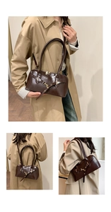 Detail view of dark brown oil wax leather bag with golden buckles and sleek texture