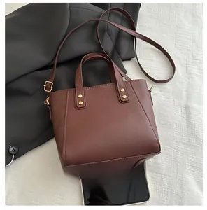 Vue détaillée du sac cabas en simili cuir marron foncé mat avec rivets dorés et bandoulière