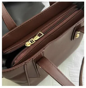Détail macro de la fermeture éclair en métal doré et des coutures sur sac à main brun