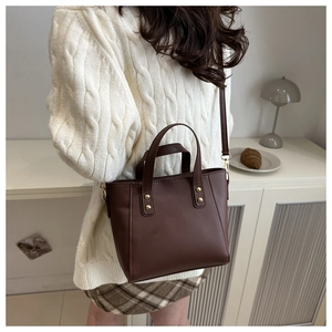 Détails du sac cabas en cuir marron foncé avec rivets dorés et poignée arrondie