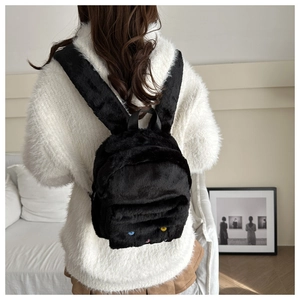 Detailansicht eines süßen schwarzen Plüschrucksacks mit Cartoon-Augen-Design