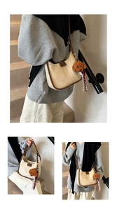 Detail of off-white faux leather hobo bag with brown trim and cute teddy charm