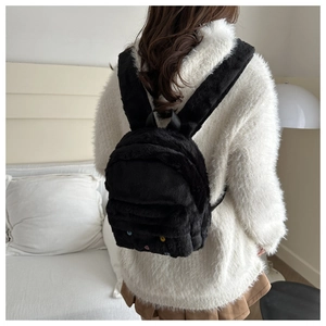 Detail eines schwarzen Plüschrucksacks mit Katzen-Design und weichen Schultergurten