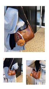 Detail of a brown retro shoulder bag with a teddy bear charm and colorful scarf