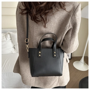 Détail d'un sac à bandoulière en cuir PU noir avec rivets dorés et bandoulière réglable