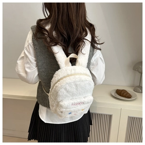 Detail eines weißen Plüschrucksacks mit süßen Hasenohren und Mode-Stickerei