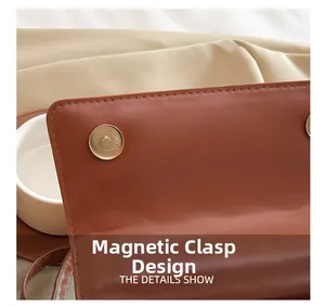 Détail du sac en cuir marron avec double système de fermeture magnétique dorée
