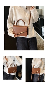 Detail of brown litchi pattern leather bag with V-shaped flap and gold metal bar accent
