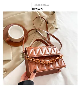 Détail du sac à bandoulière matelassé marron avec chaîne mate et fermoir métallique chic