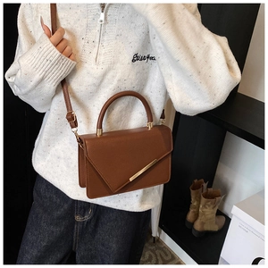 Detail der braunen Leder-Tasche mit Litschimuster, Goldleiste und Umschlagklappe
