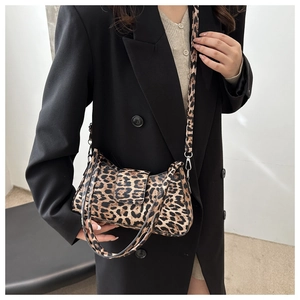 Brown leopard print crossbody bag with dual straps shown on a stylish black blazer