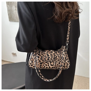Detail of leopard print shoulder bag featuring flap closure and detachable black strap