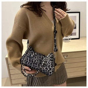 Détail d'un sac Boston à motif léopard porté à l'épaule avec une bandoulière large