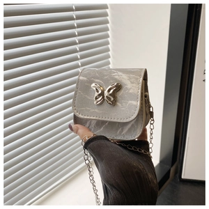 Detail of grey marble pattern mini bag with silver butterfly clasp and chain strap