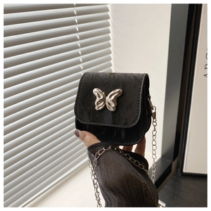 Mini black velvet crossbody bag featuring silver butterfly ornament and delicate chain strap