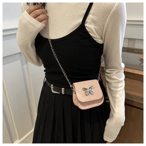 Pink mini leather crossbody bag with butterfly detail and silver chain on model