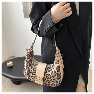 Dettaglio borsa a mezzaluna leopardata con finiture in pelle marrone e fibbia dorata