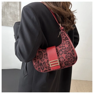 Dettaglio borsa hobo leopardata rossa con fibbia dorata su modella con blazer nero