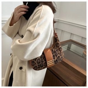 Détail du sac sous le bras à motif léopard avec bordure en cuir brun et boucle dorée