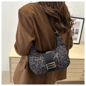 Détail d'un sac porté épaule léopard avec boucle en métal doré et sangle noire