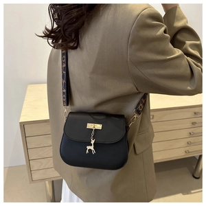 Chic black saddle bag with golden deer pendant and decorative wide jacquard strap