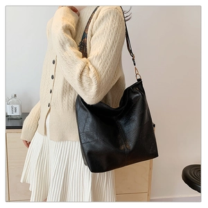 Close-up of a black tote bag with a colorful geometric wide shoulder strap for women