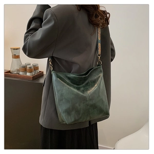 Detail of a dark green hobo bag featuring a retro texture and ethnic style jacquard strap