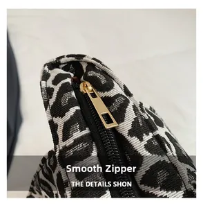 Close-up of smooth gold metal zipper on black and white animal print woven tote bag
