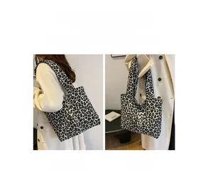 Detail showing high-capacity leopard print tote bag with shoulder and handheld options