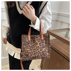 Detail shot of the stylish leopard print tote bag featuring brown leather top handles
