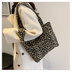 Detail of trendy leopard print canvas tote bag with wide strap worn with white coat