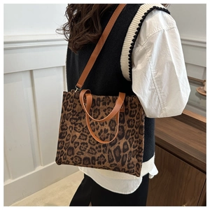 Close-up of leopard print tote bag with brown faux leather straps and fine fabric texture