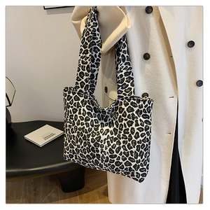 Close-up of stylish leopard print tote bag showing fabric texture and shoulder strap