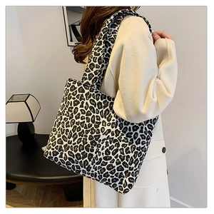 Close-up of leopard print tote bag with wide strap paired with a beige wool coat