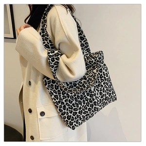 Close-up of black and white leopard print canvas tote bag with wide shoulder strap details