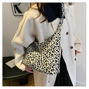 Modische Tote Bag mit Leopardenmuster und breitem Gurt, präsentiert von einem Model im Raum