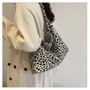 Detailed view of large leopard print canvas tote bag styled with a minimalist beige coat