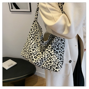 Detail of large black and white leopard print tote bag worn on shoulder by model