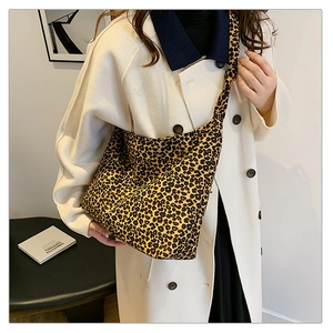 Fashionable leopard print crossbody bag with wide strap worn by a model in style
