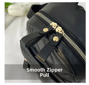 Detail of black PU leather backpack with V-quilted texture and smooth gold zipper slide