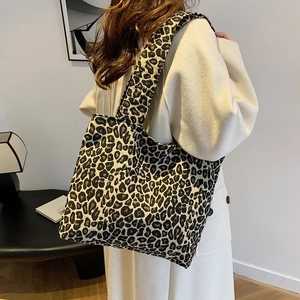 Fashionable leopard print canvas tote bag with wide strap styled with a long cream coat